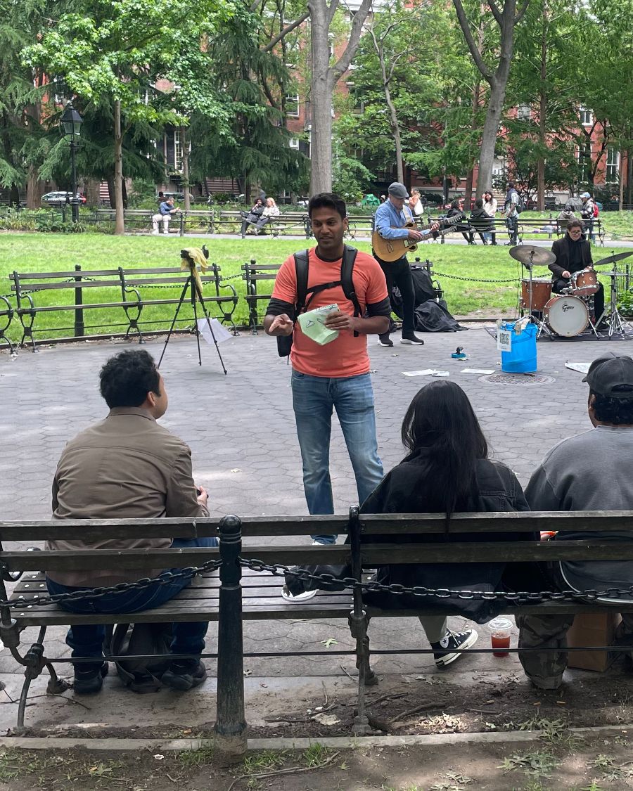 A guide leading a small group through Washington Square Park as a jazz trio plays behind them